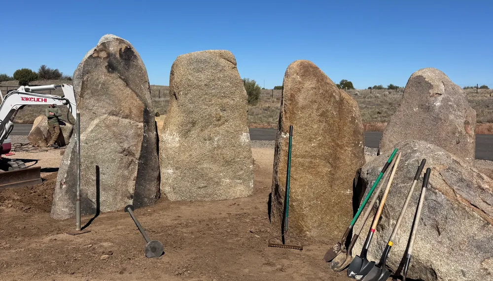Standing granite monolith feature set with heavy equipment in Chino Valley