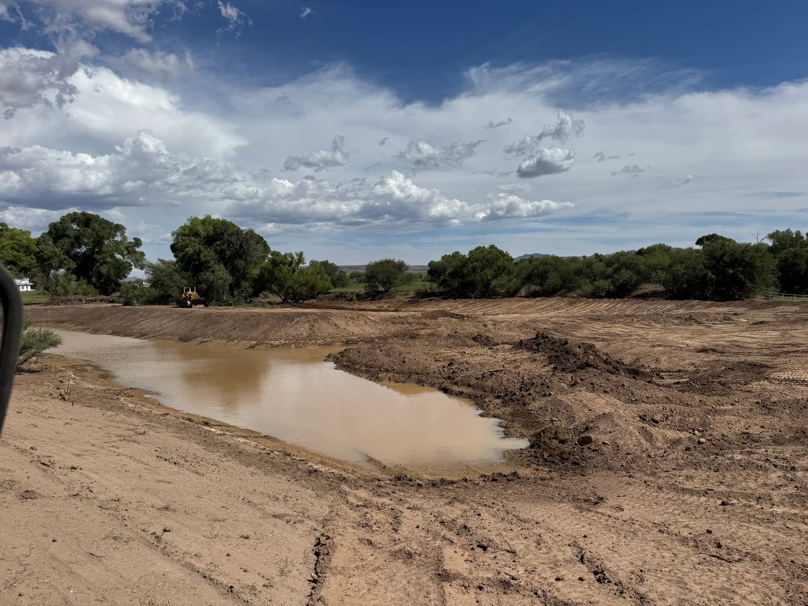 Freshly excavated ranch pond holding water on a rural property near Prescott